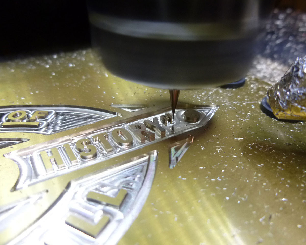 My mini-mill at work carving the details around the lettering on a heritage way marker I was commissioned to make.  The tool's a 0.4mm end-mill.